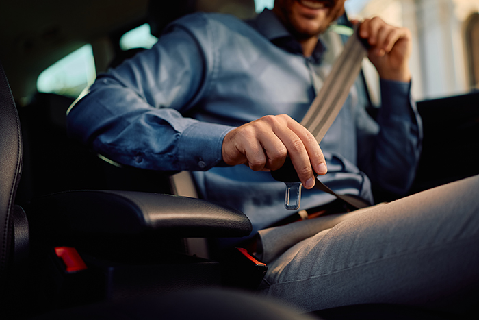 Close,Up,Of,Businessman,Fastening,Seatbelt,While,Driving,Car.